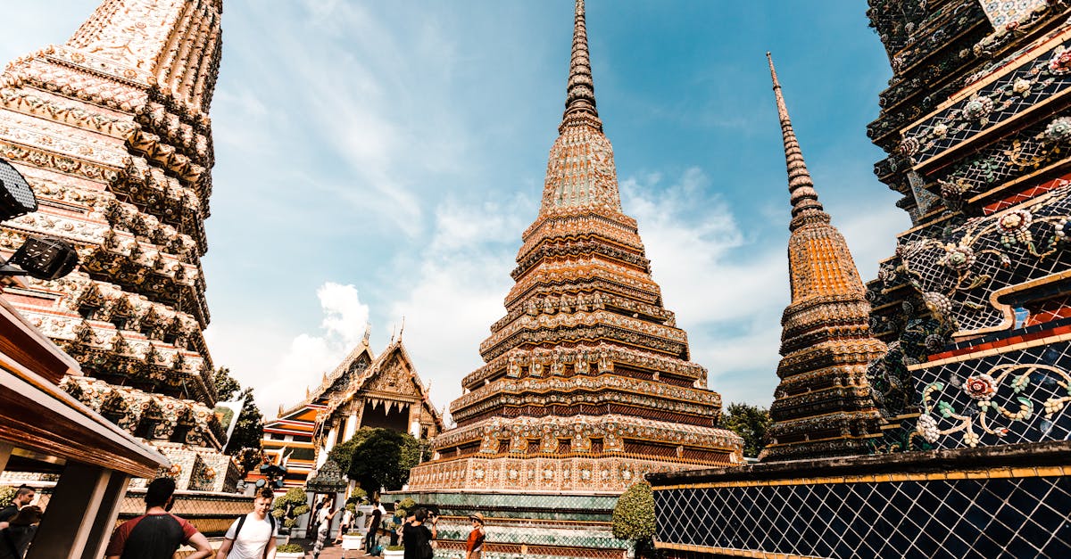 Stunning view of traditional pagodas at Wat Pho under a vibrant blue sky in Bangkok, Thailand.