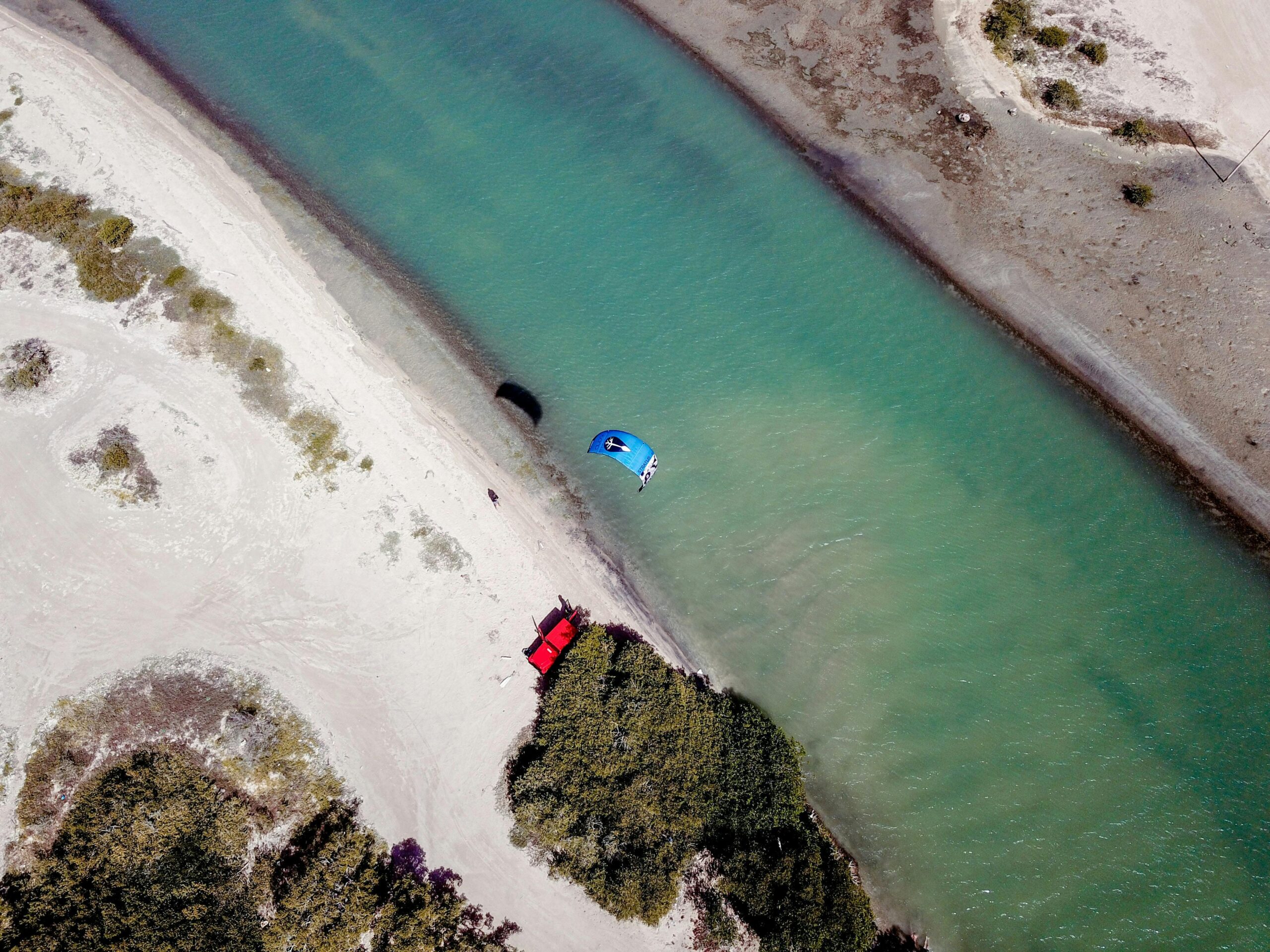 Paraglider over a scenic coastal river in El Supí, Falcón, Venezuela.